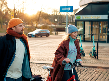 Två personer - en man och en kvinna - vandrar över ett torg.